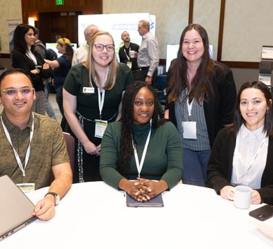 Group of attendees taking a photo at a table
