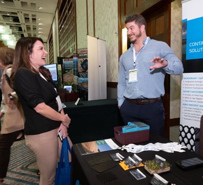 Attendee & sponsor laughing at booth